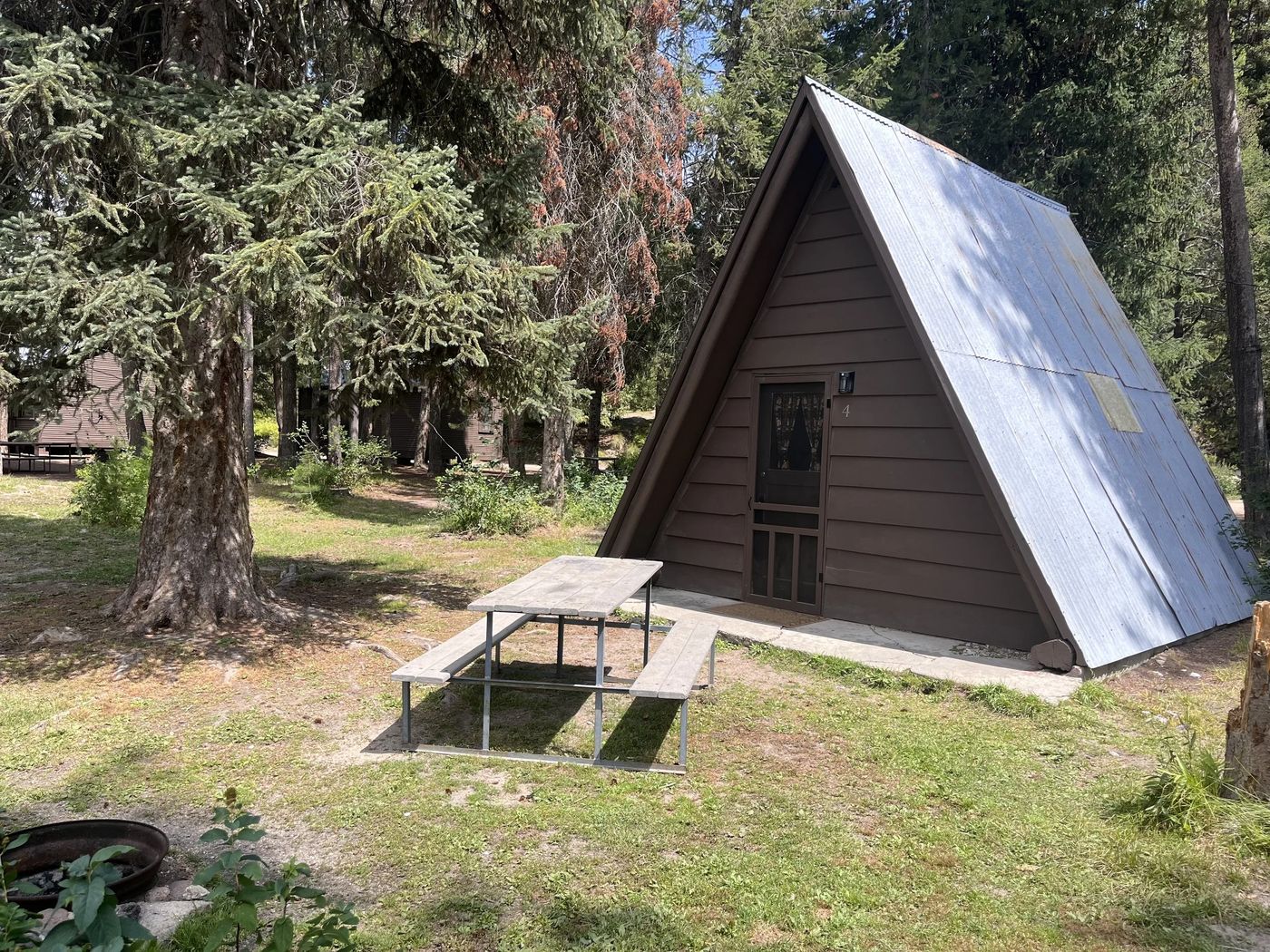 A-frame cabin in the forest with picnic table
